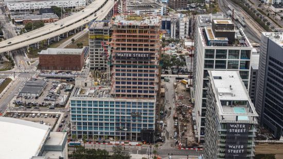 The Tampa Edition hotel and residences (center, with a 'Water Street' banner on the front side) have topped out at 26 stories and are expected to open in late 2021. [ Strategic Property Partners ]